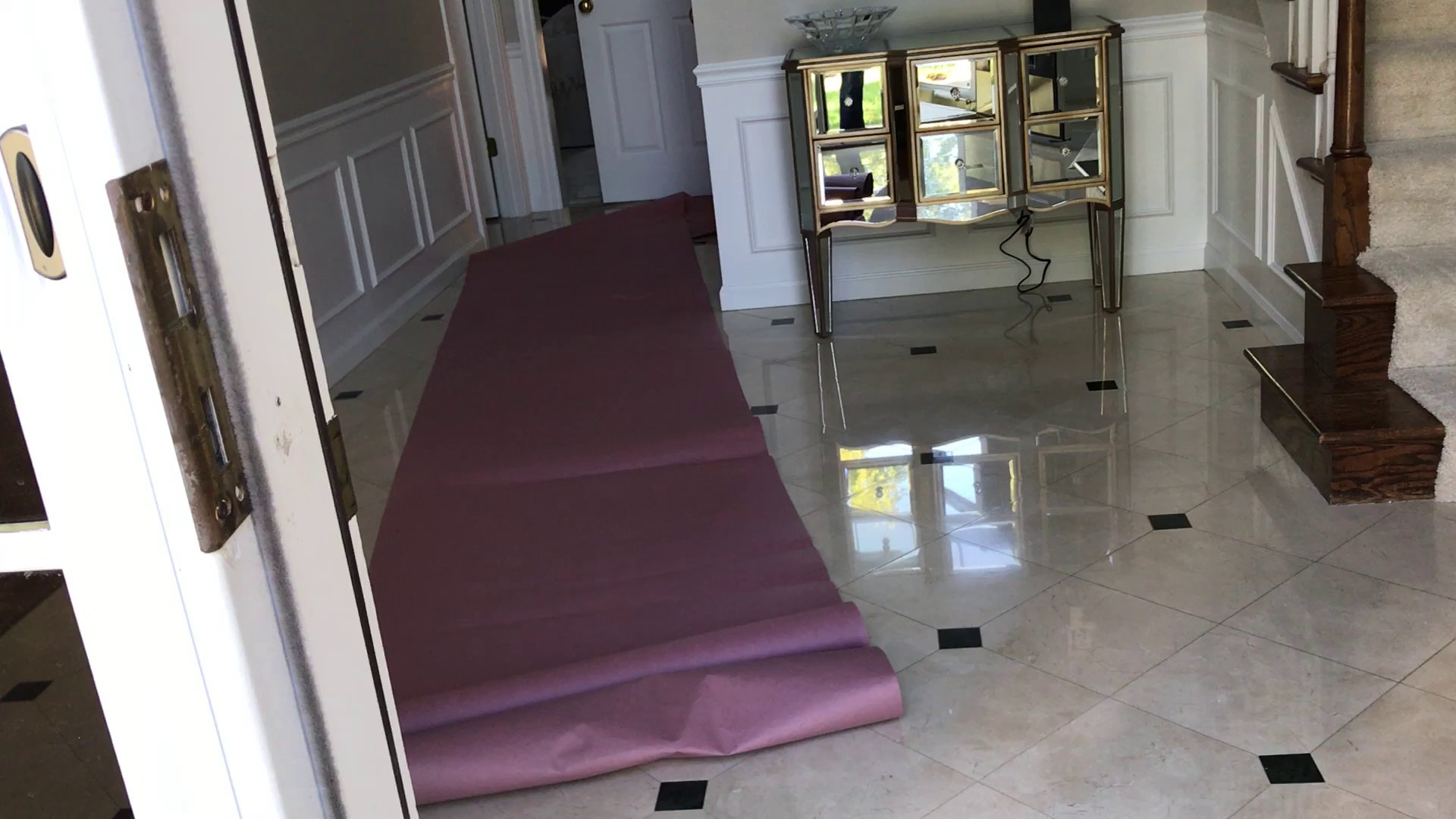 Pink carpet runner laid across tiled hallway floor