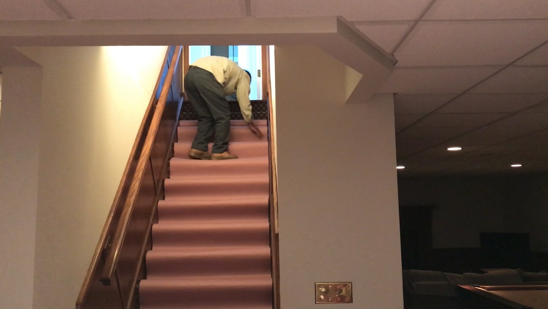 Man bending over on carpeted staircase indoors