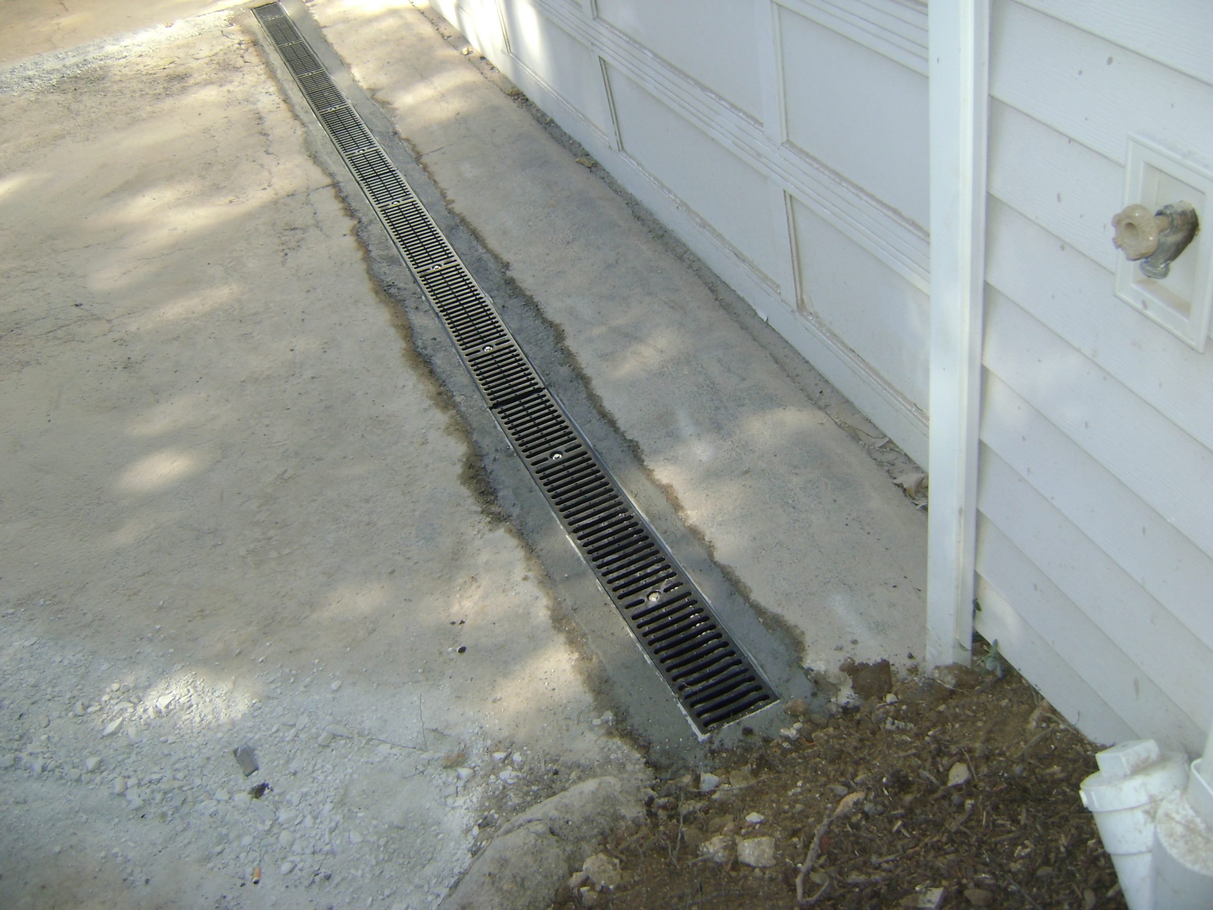 Linear trench drain along concrete driveway