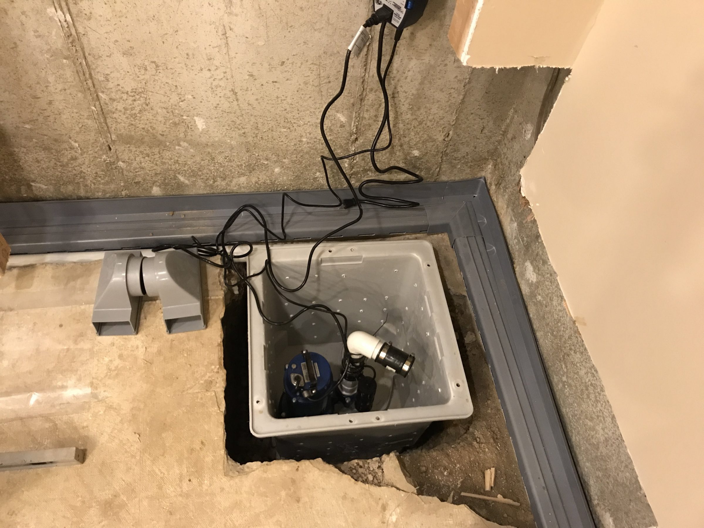 Basement sump pump installed in floor pit
