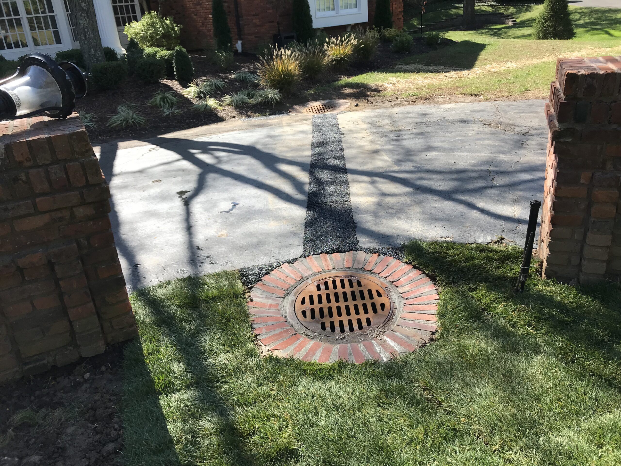 Brick-lined storm drain at residential driveway entrance