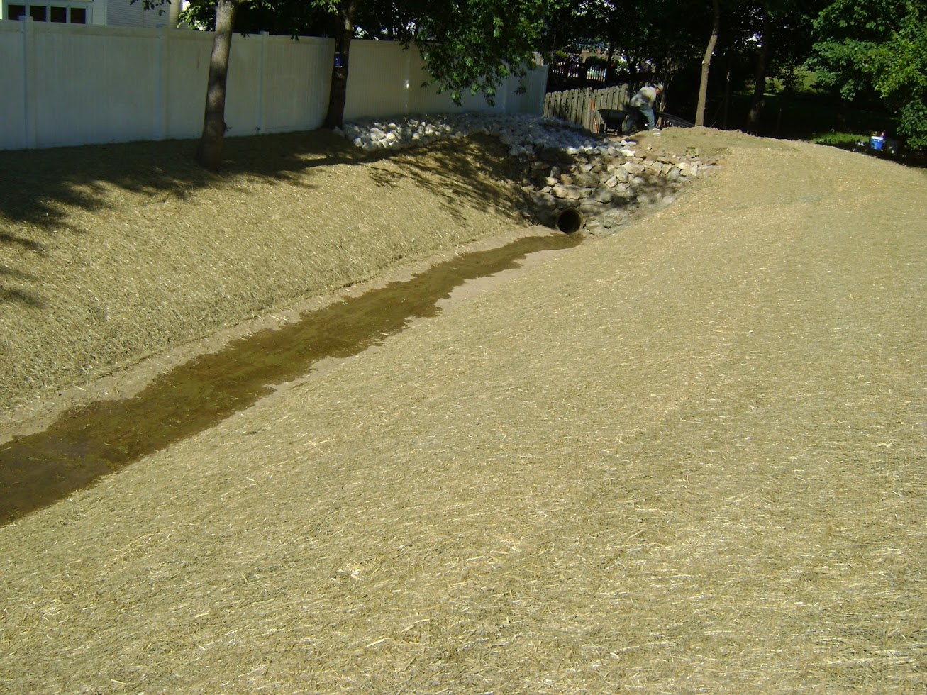 Straw-covered drainage ditch with culvert and small stream