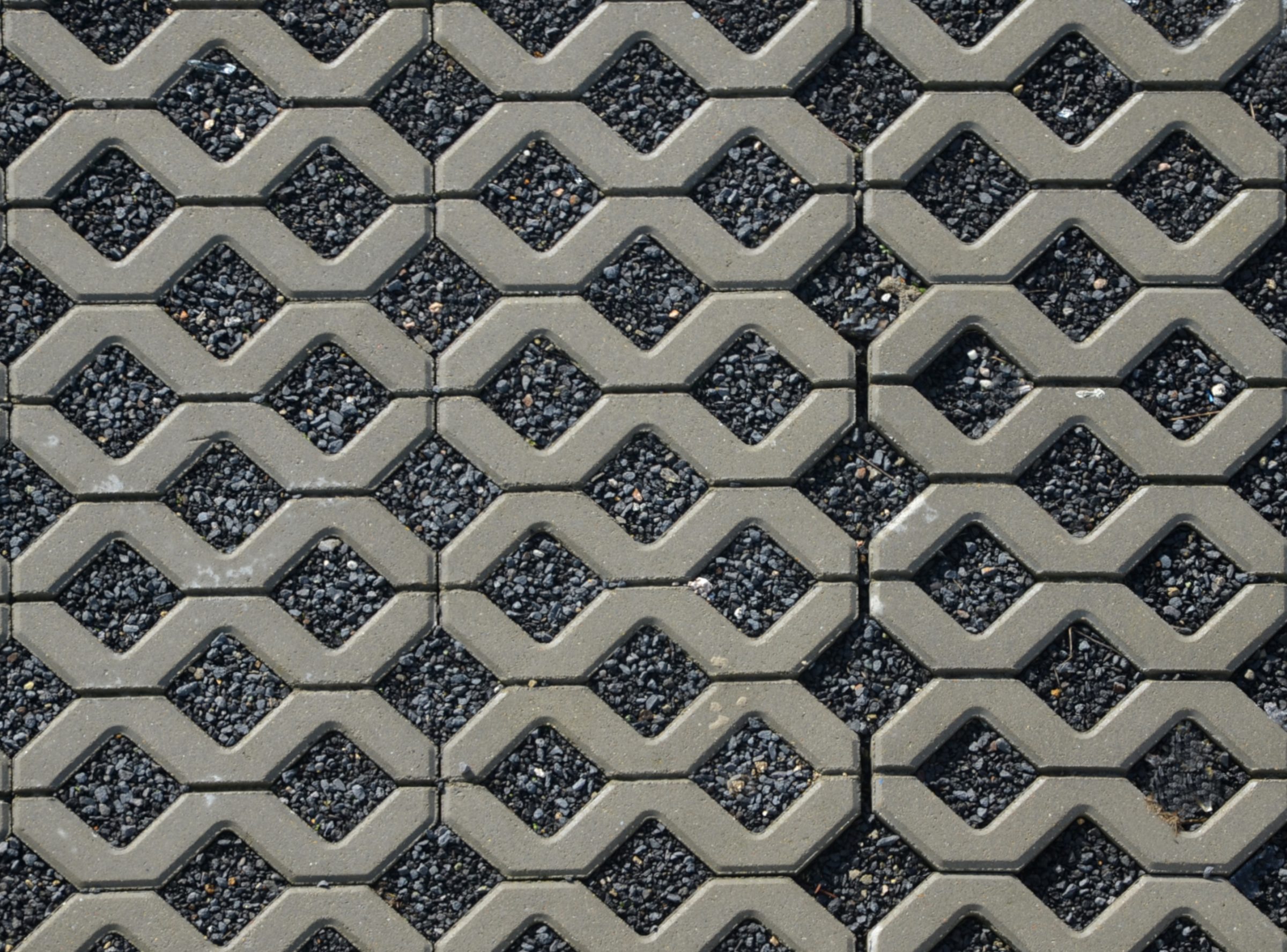 Interlocking concrete pavers with gravel-filled openings