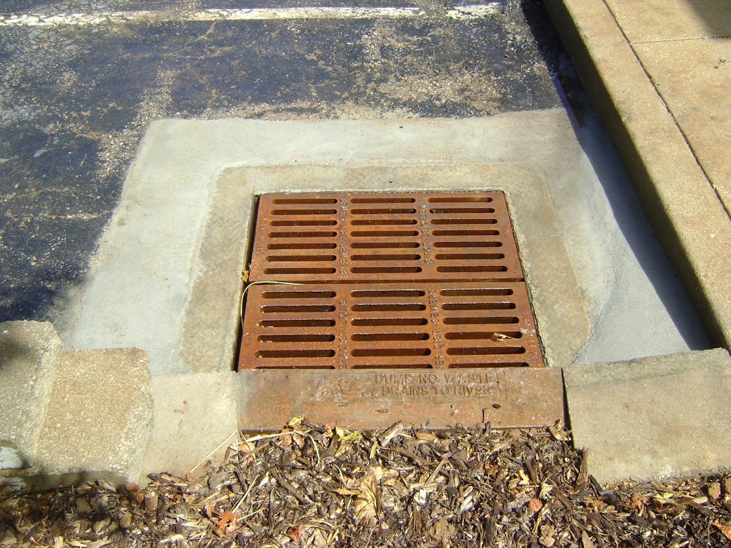 Storm drain grate set in concrete curb