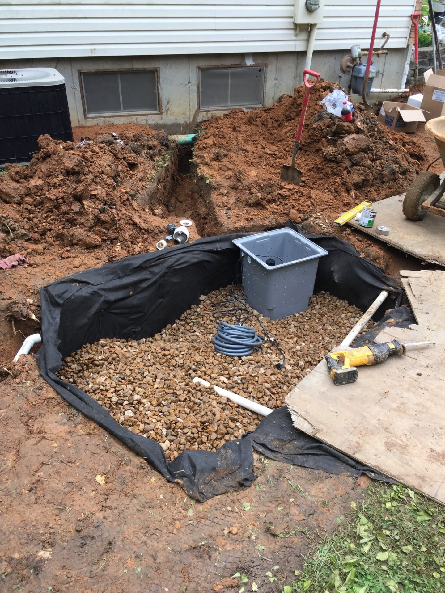 Backyard sump pump installation near house foundation