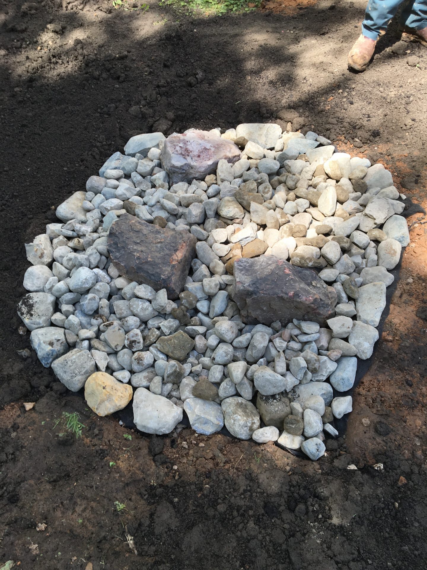 Gravel and large stones in dug ground pit