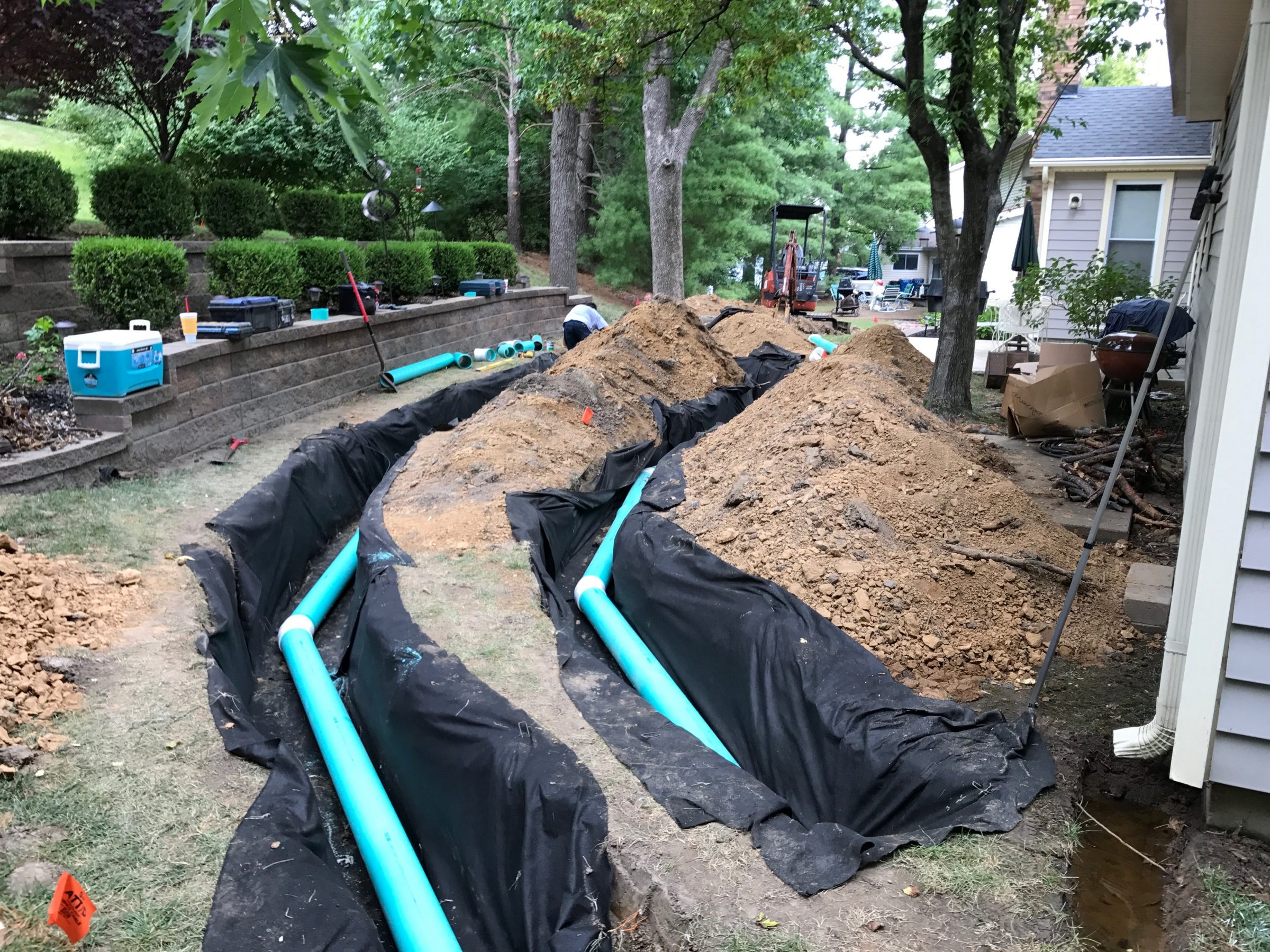 Backyard trenching with green drainage pipes installed