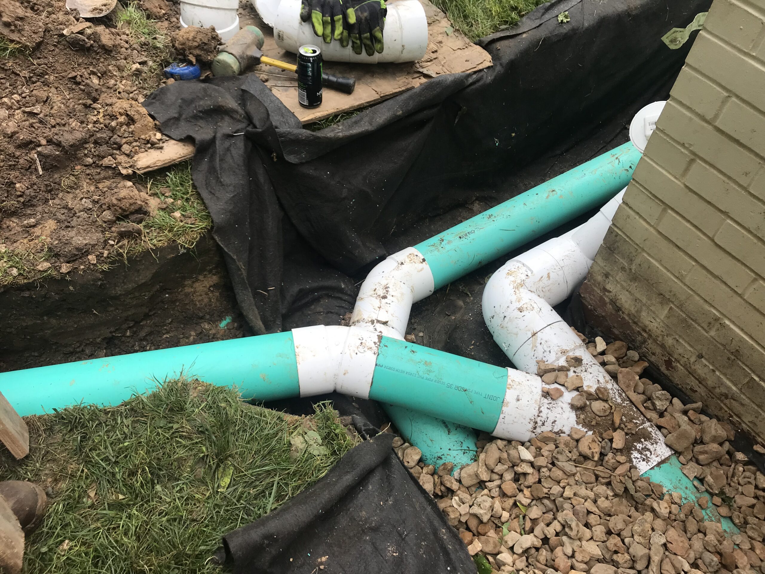Foundation drainage pipes installed beside house wall