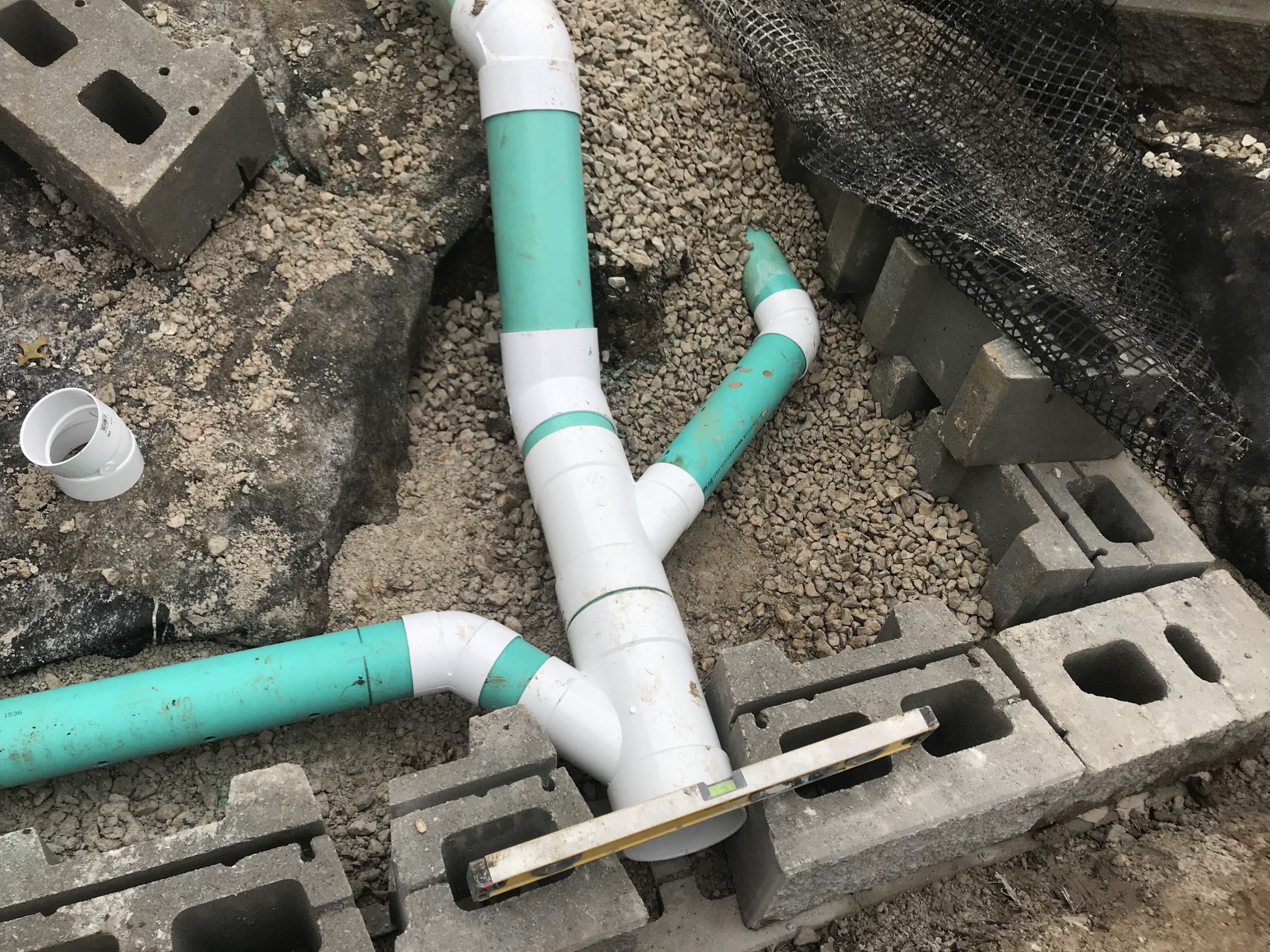 PVC drainage pipes laid in gravel foundation trench
