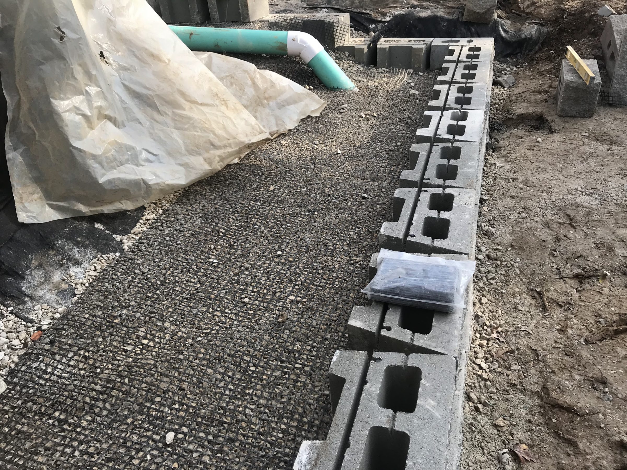 Cinder block foundation with gravel and drainage pipe