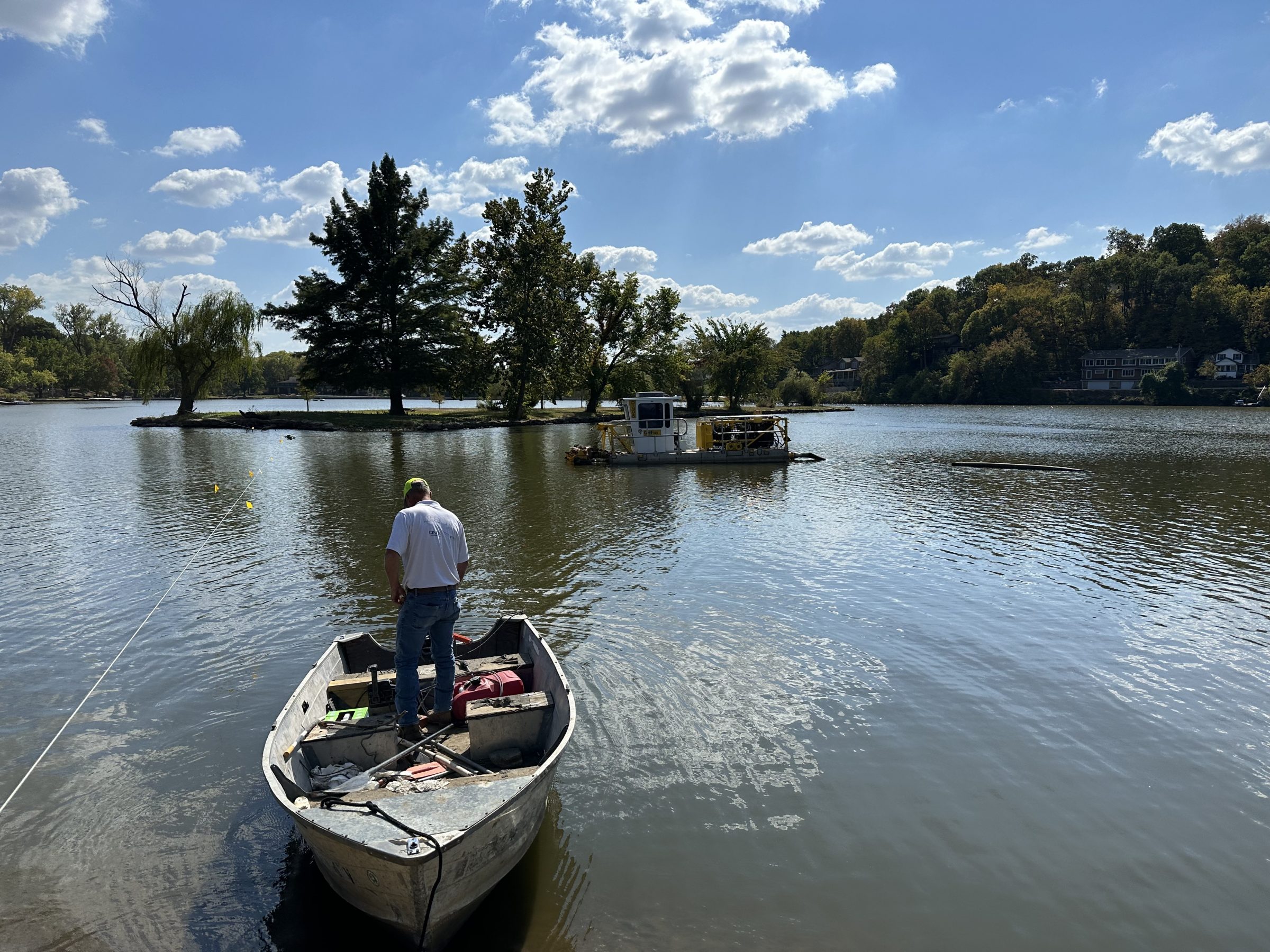 Man standing in boat on calm lake