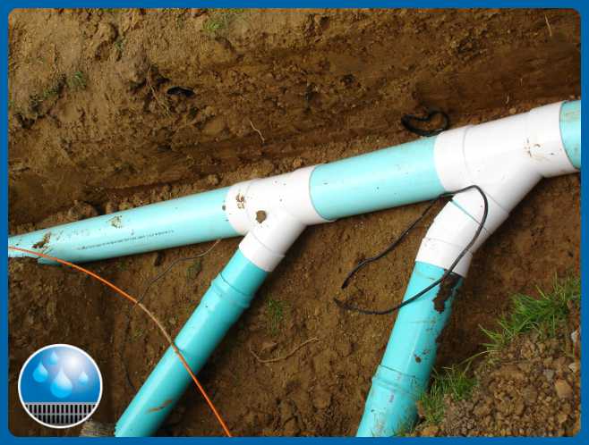 Underground PVC plumbing pipes in dirt trench