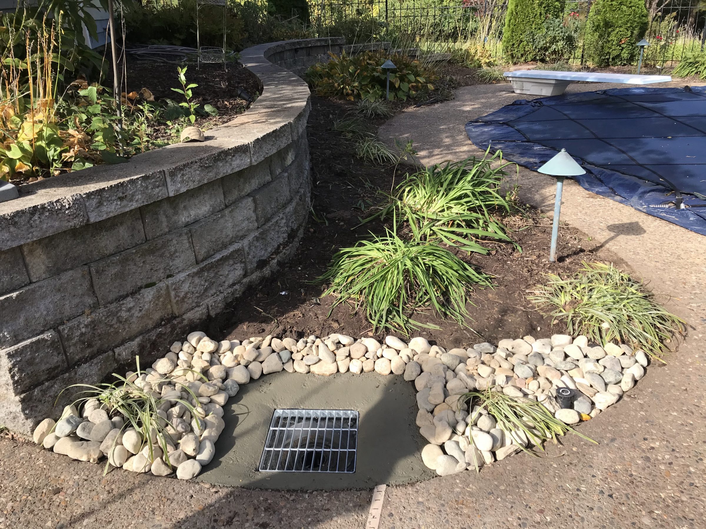Backyard retaining wall with drainage and landscaping