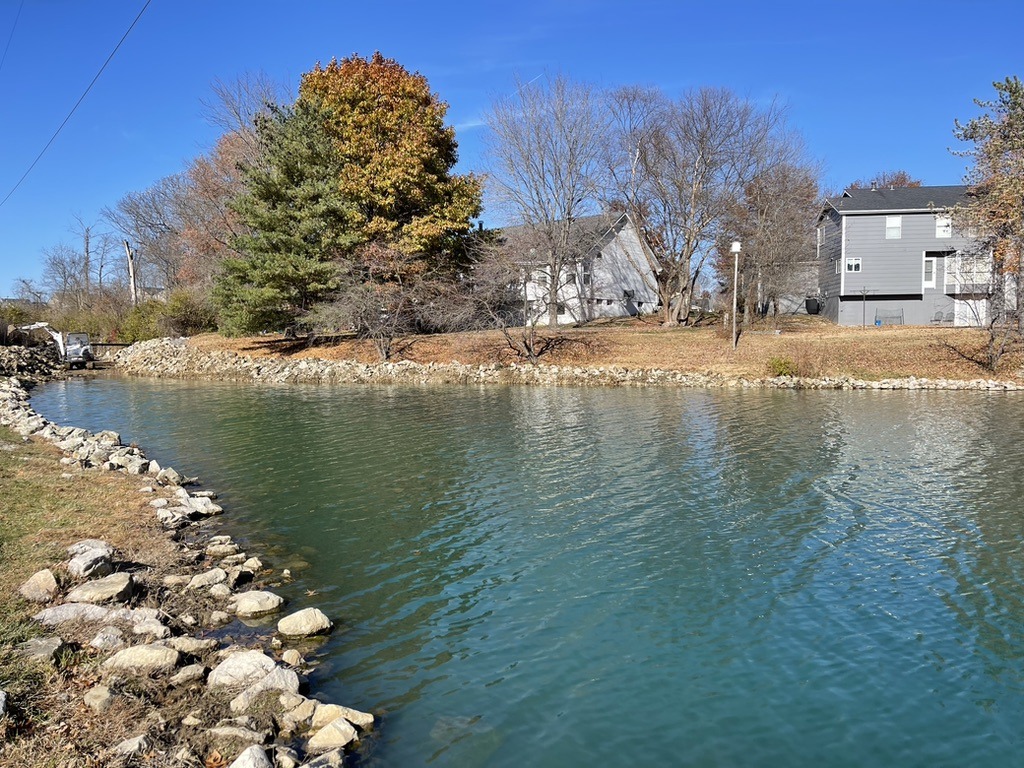 Canal with rocky shore and houses in autumn