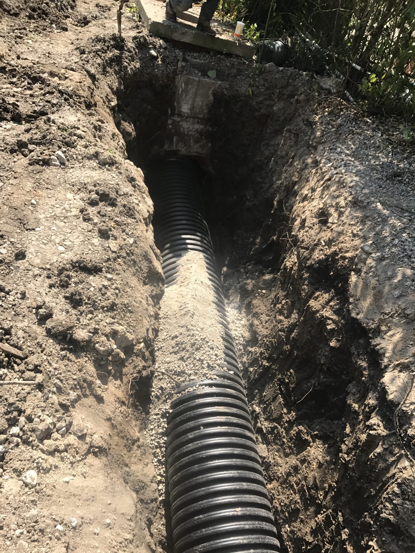Large corrugated drainage pipe in excavated trench