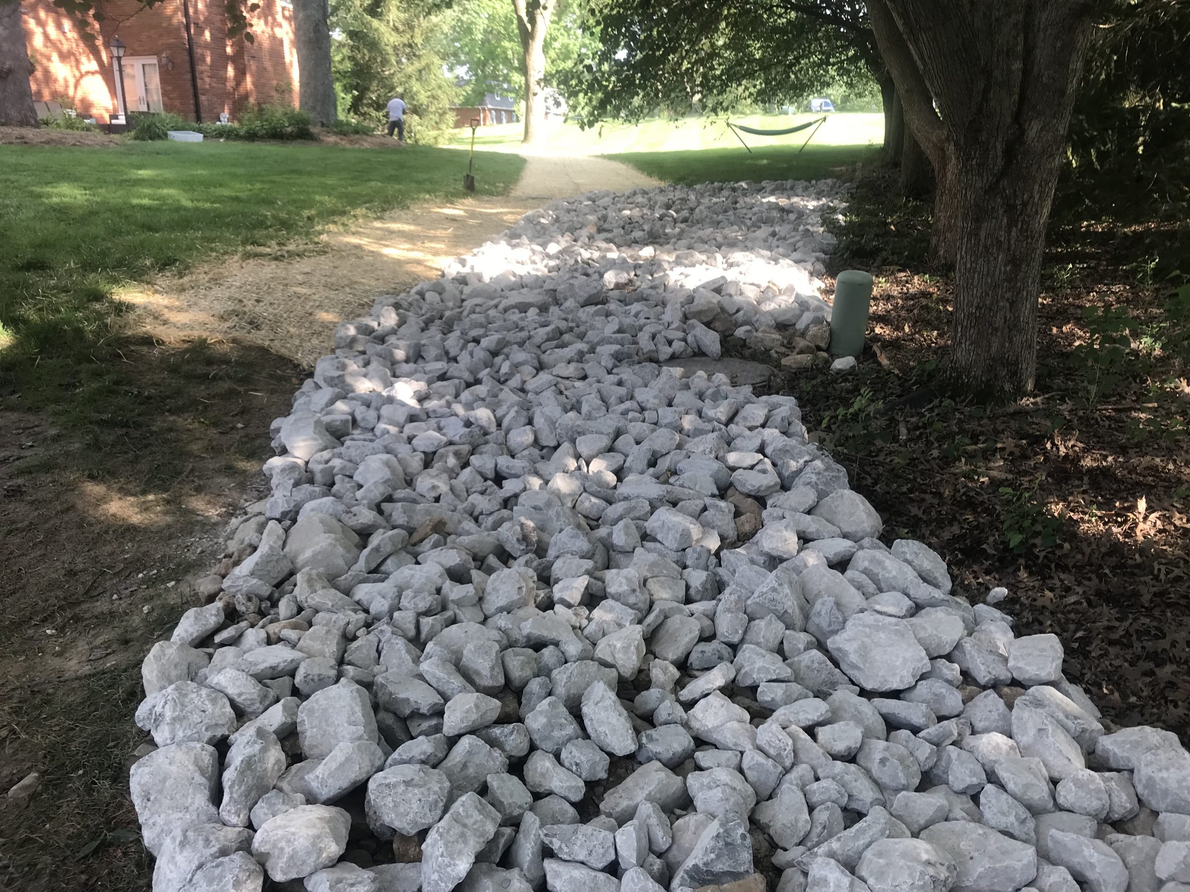 Rock-filled drainage ditch beside grassy yard