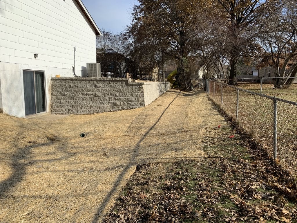 Backyard with retaining wall and chain-link fence