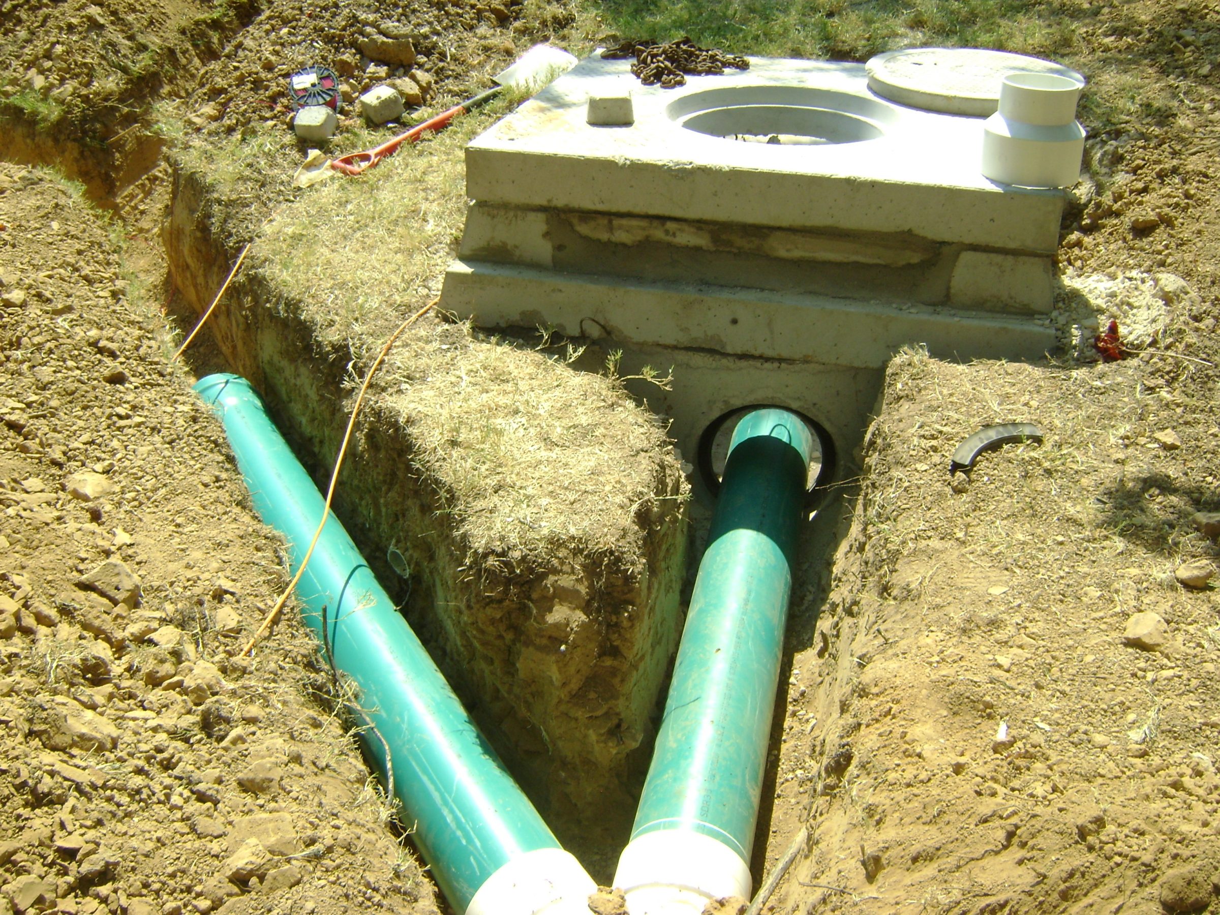 Concrete septic tank with green sewer pipes