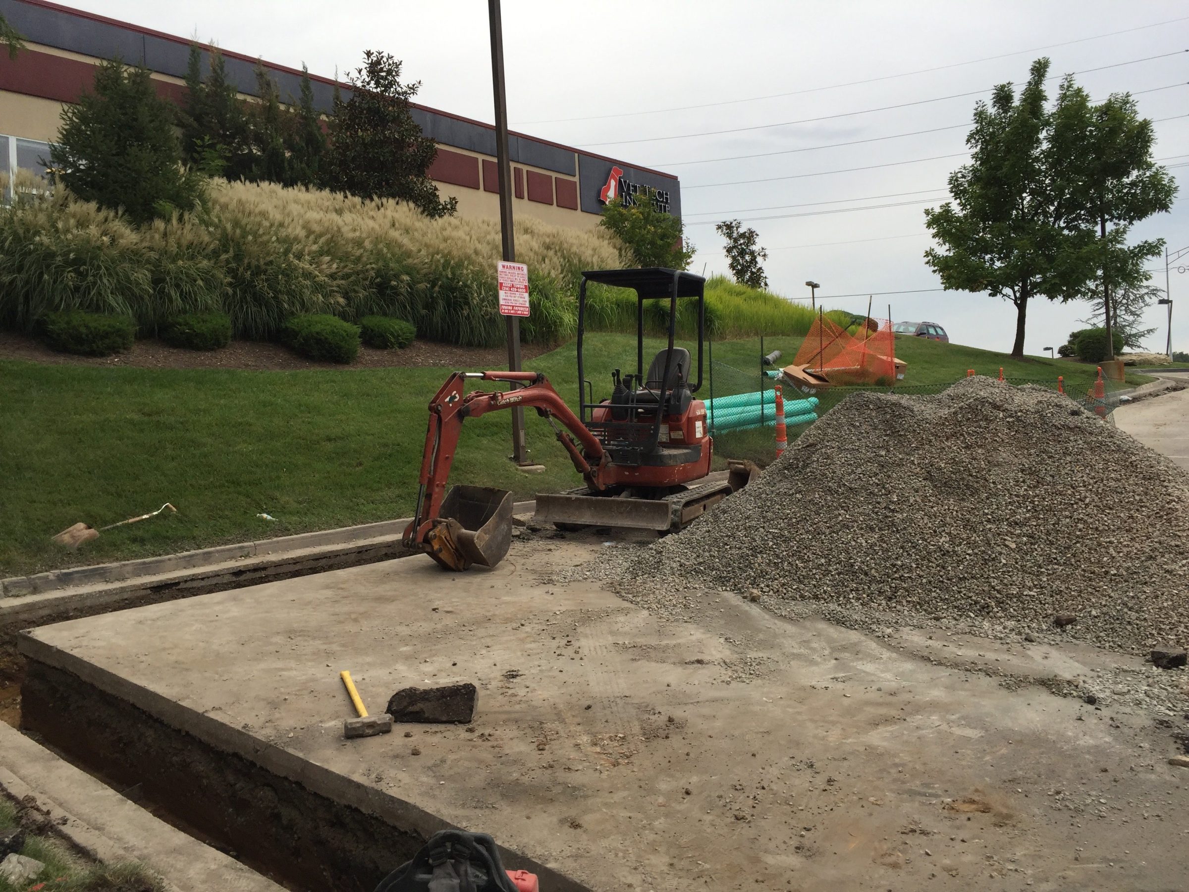 Mini excavator beside gravel pile at construction site