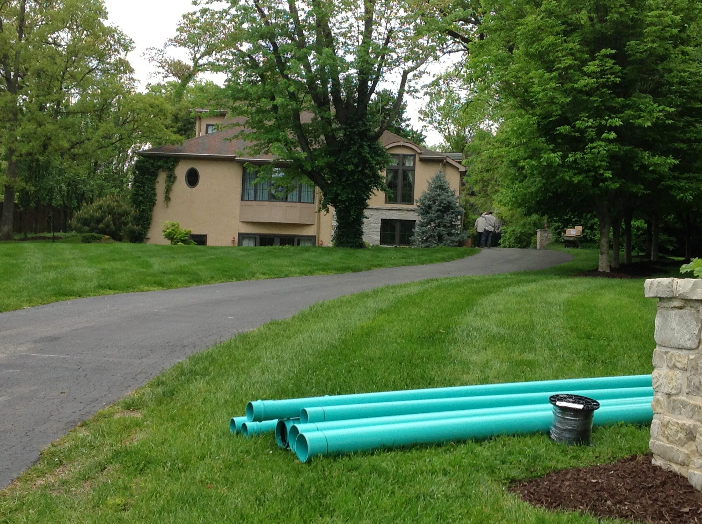 Suburban house with driveway and green pipes
