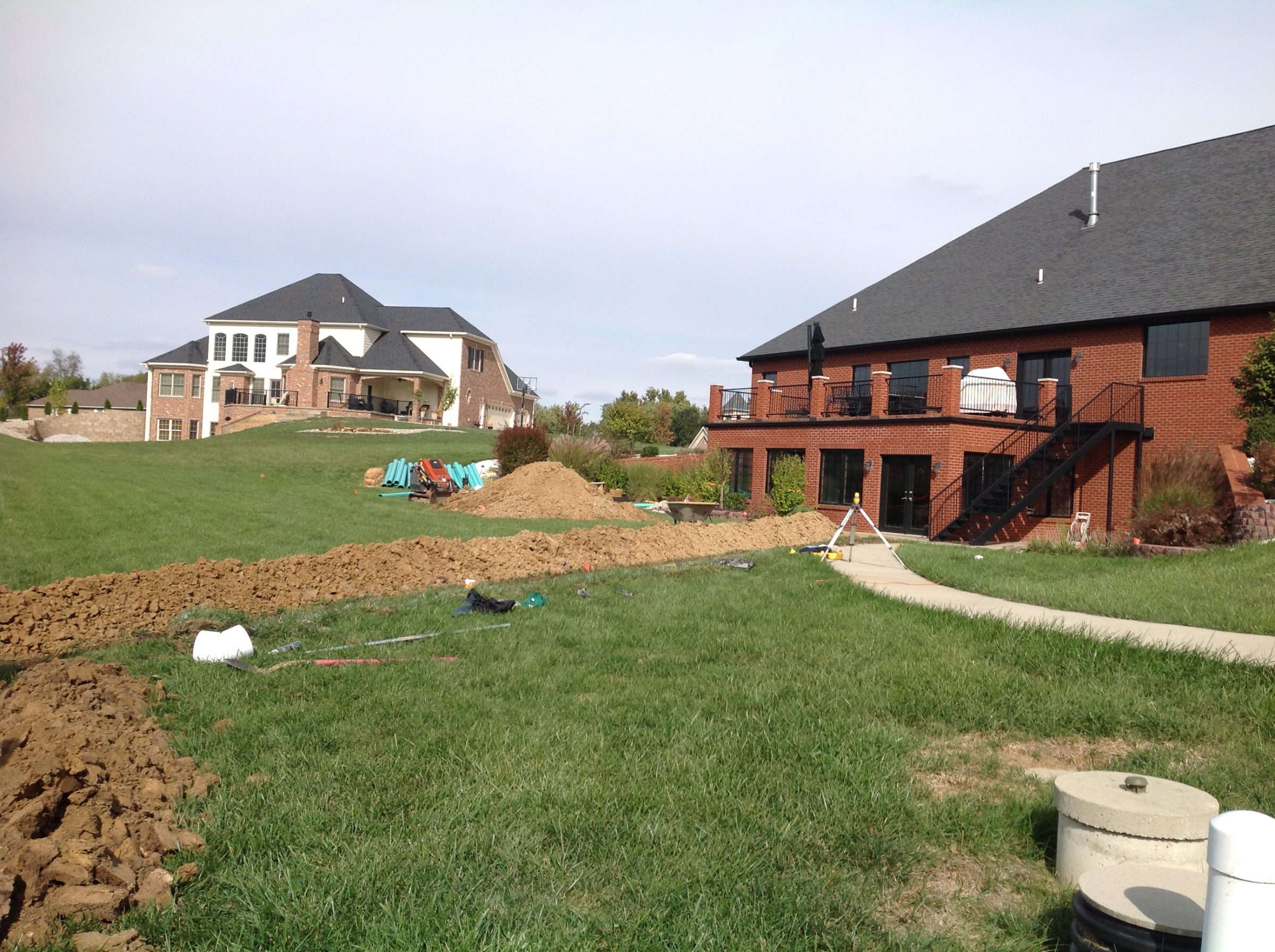 Backyard trenching near brick suburban homes
