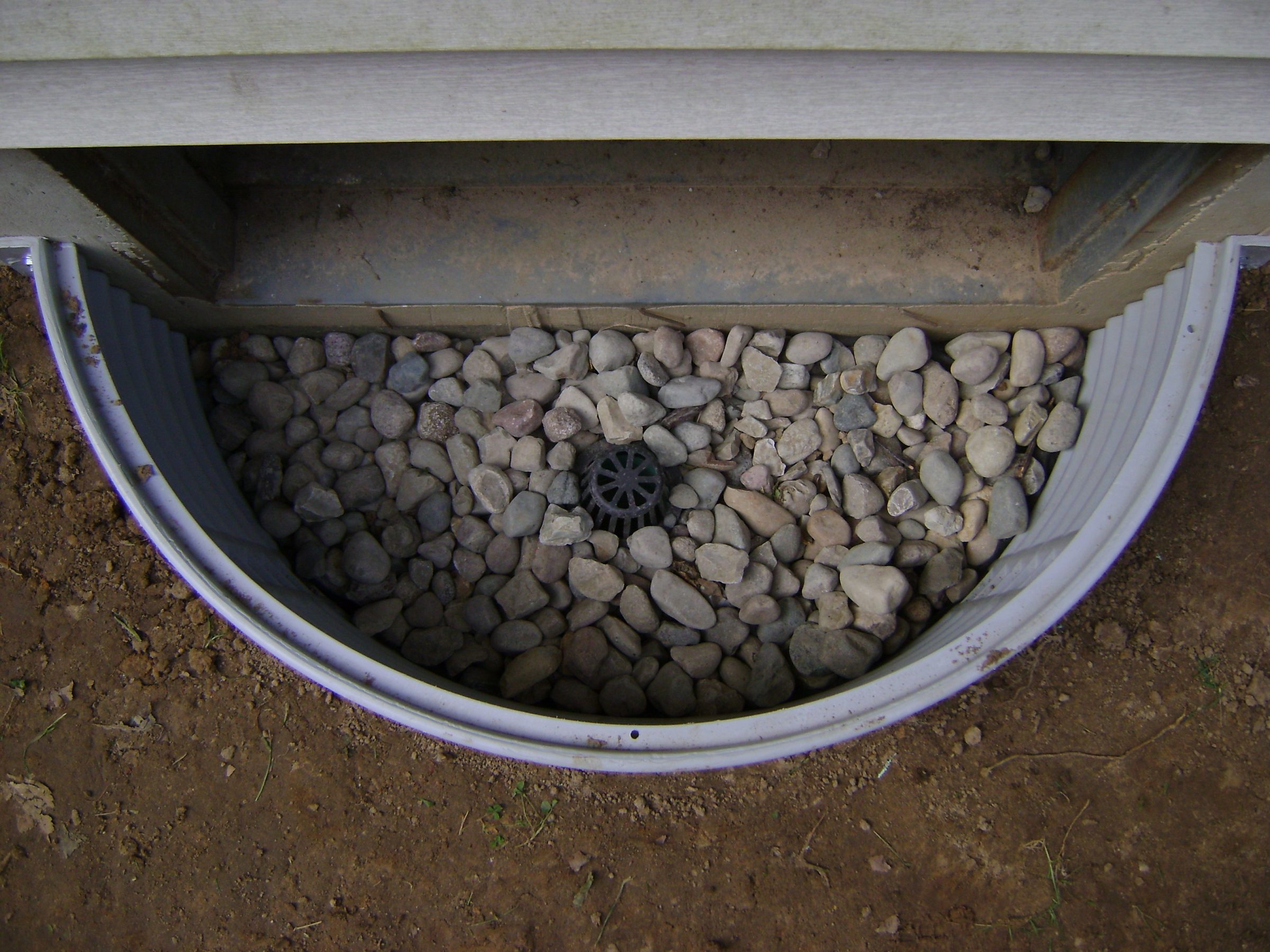 Window well with gravel and central drain