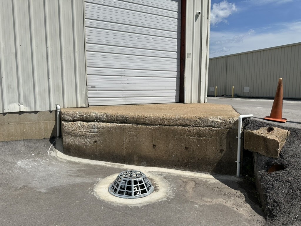 Industrial loading dock with drain and traffic cone