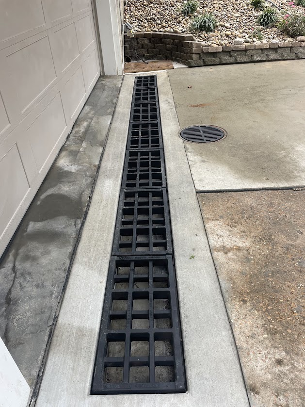 Long trench drain installed along garage driveway