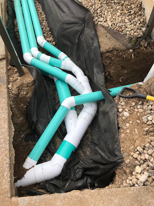 Underground plumbing pipes in trench with gravel
