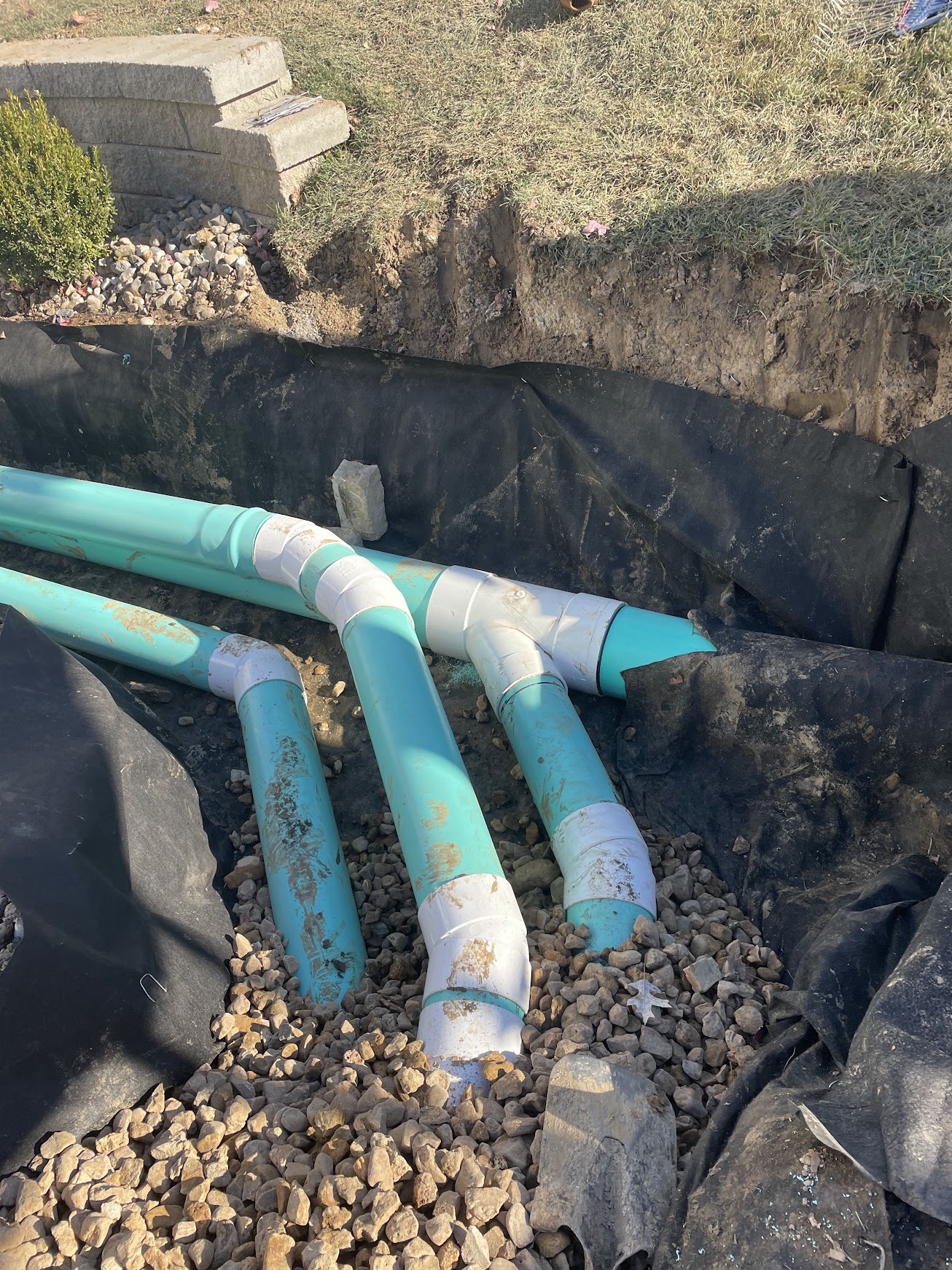 Underground PVC drainage pipes in gravel-lined trench