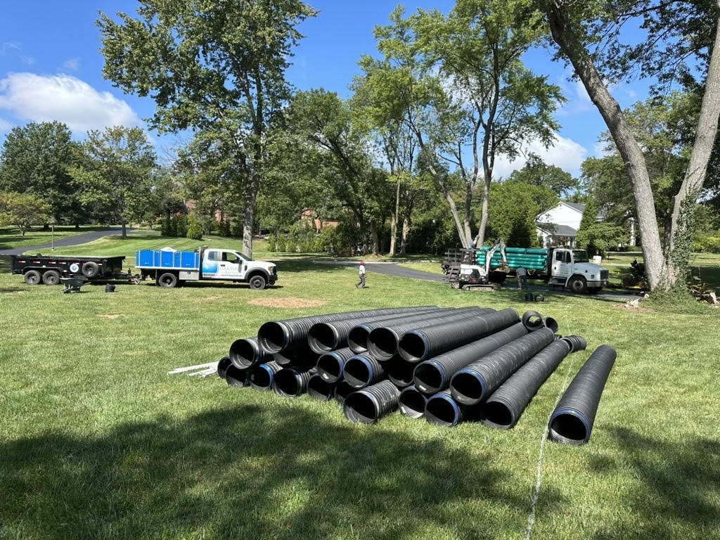 Large black drainage pipes on grassy field